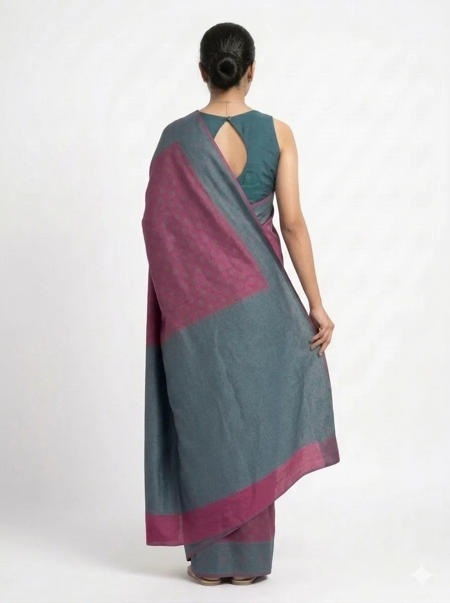Back view of a woman wearing a magenta & charcoal grey woven Banarasi silk blend saree, showcasing the textured grey pallu and a matching charcoal grey sleeveless blouse with a stylish keyhole back design.