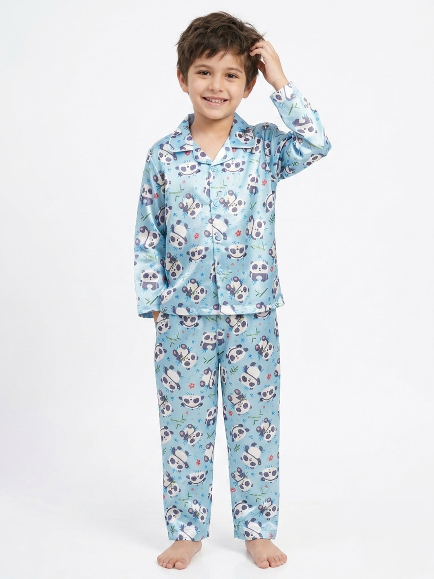 Young boy smiling in a light blue panda printed satin pyjama set.