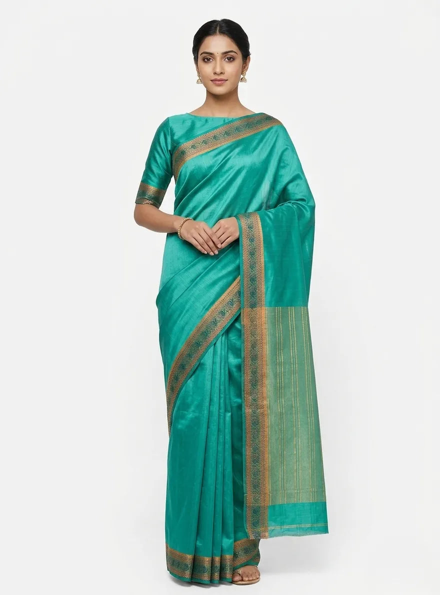 A woman modeling a teal green silk-blend saree with vertical gold stripes and a rich gold-toned zari border, styled against a plain white background.

