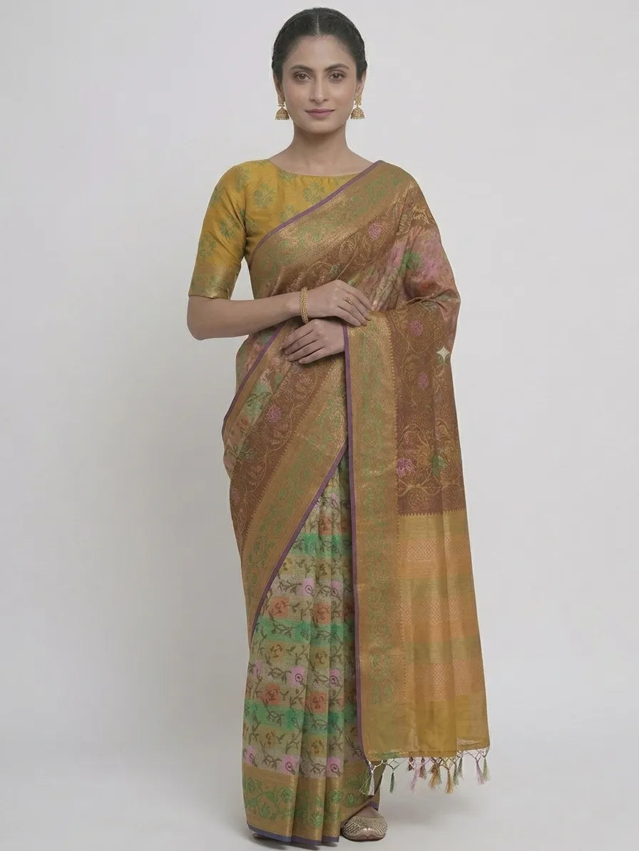 Alt Text:
A woman in a mustard and olive green floral printed silk blend saree, featuring a purple piped border, a woven zari pallu, and handcrafted fringe tassels.