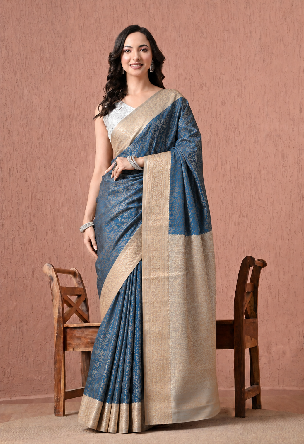 Teal blue art silk saree with gold floral motifs and woven zari-style border.