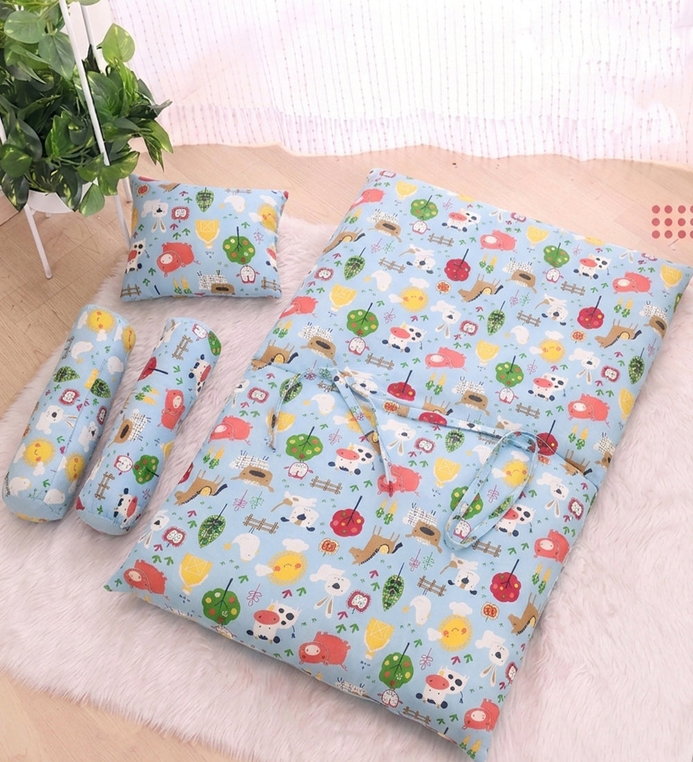 Premium 4-piece baby bedding set in light blue, featuring a 100% breathable cotton mattress, matching neck support pillow, and two bolsters with an all-over farm animal print for infants 0-6 months.