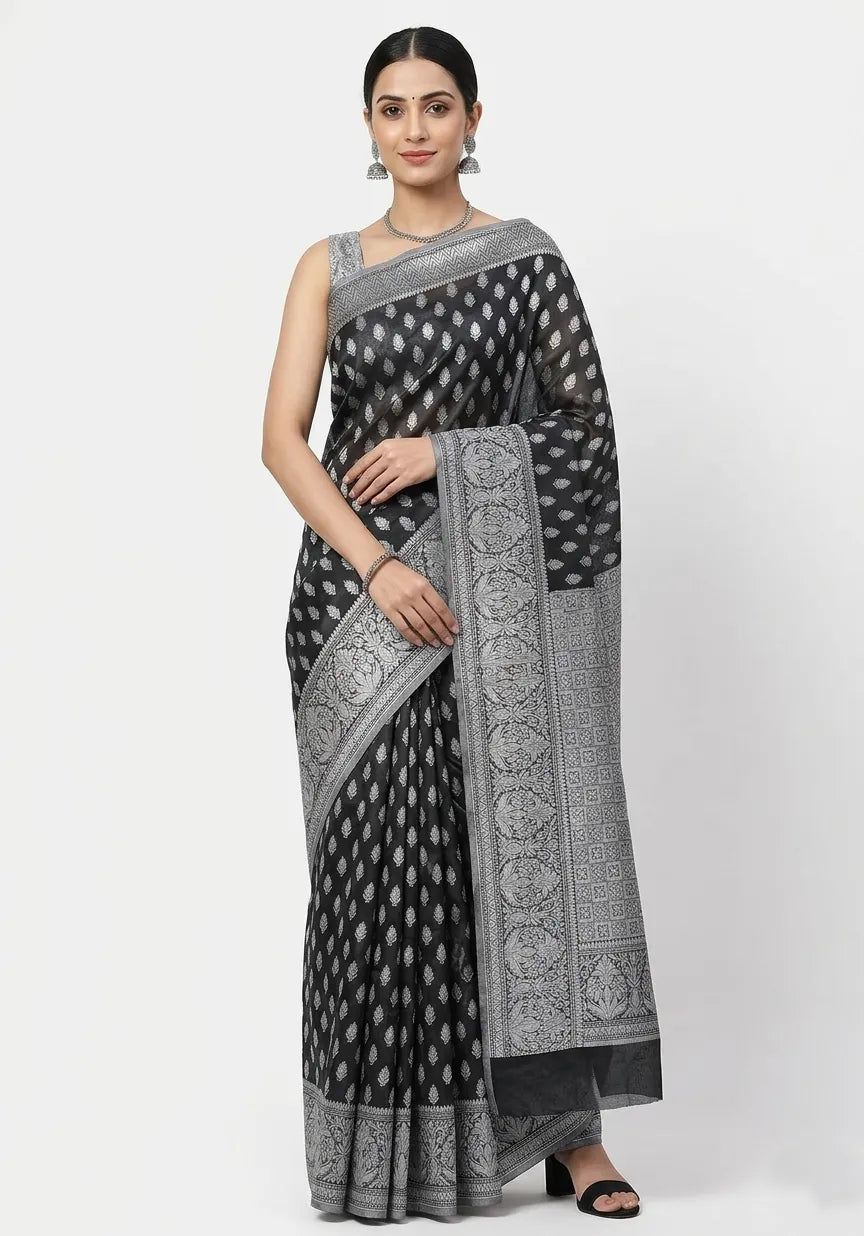 Woman in a jet black Banarasi silk blend saree featuring silver-toned leaf buttis and an intricately woven floral border.