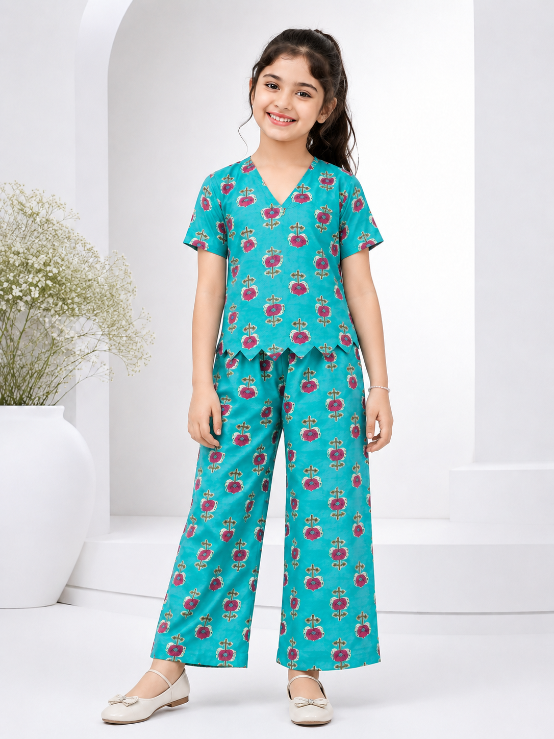 Turquoise blue floral printed two-piece co-ord set for girls featuring a scallop-hem top and wide-leg pants.
