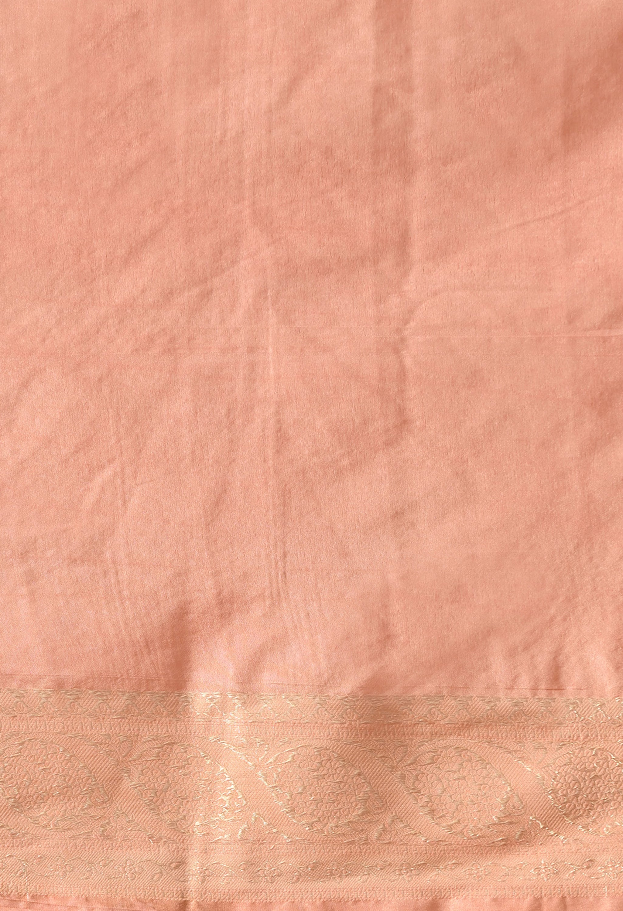 An 80 cm peach blouse piece with zari work on the hem 