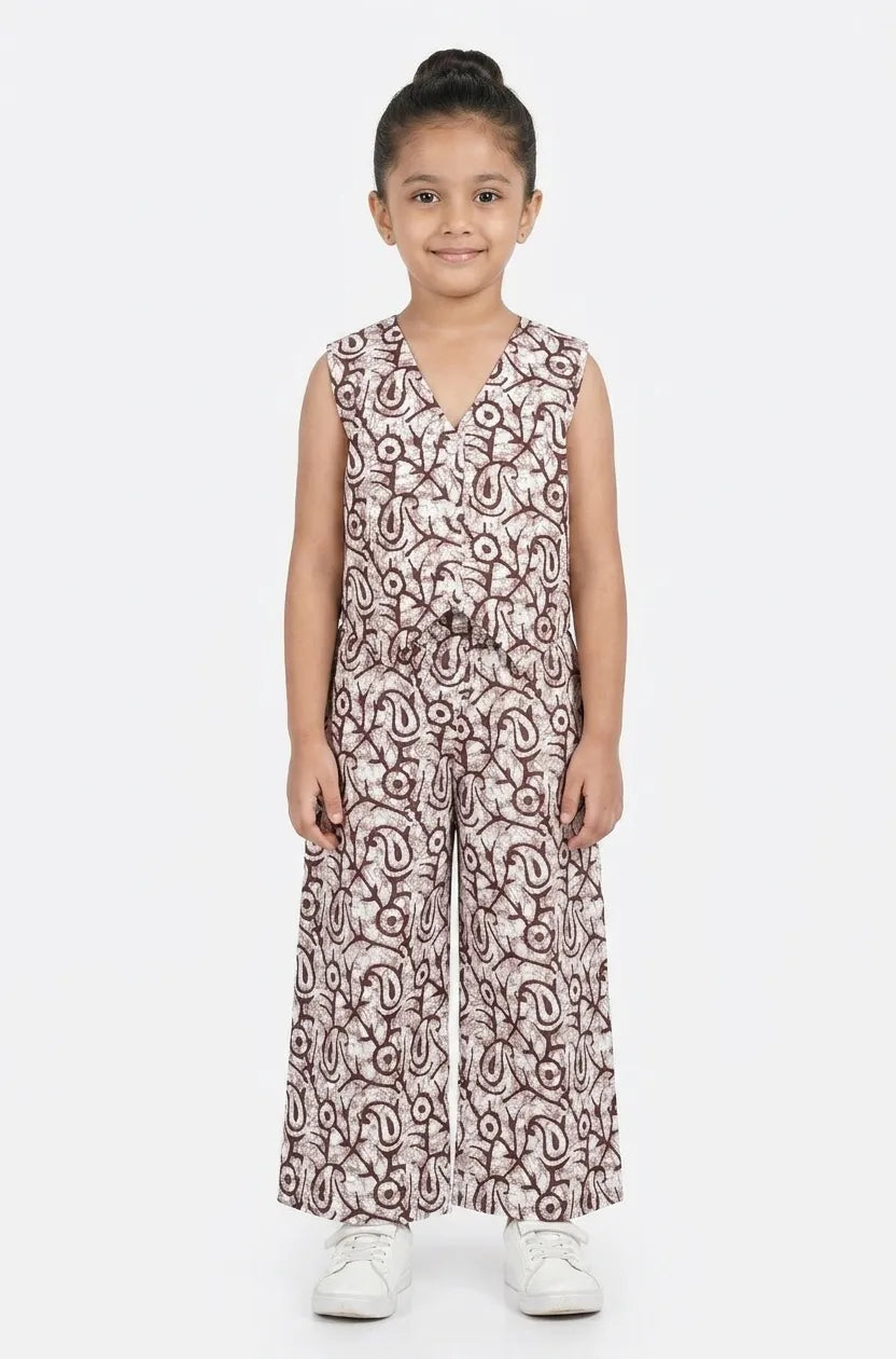 Young girl wearing a brown and white printed cotton co-ord set with a sleeveless V-neck top and wide-leg trousers.

