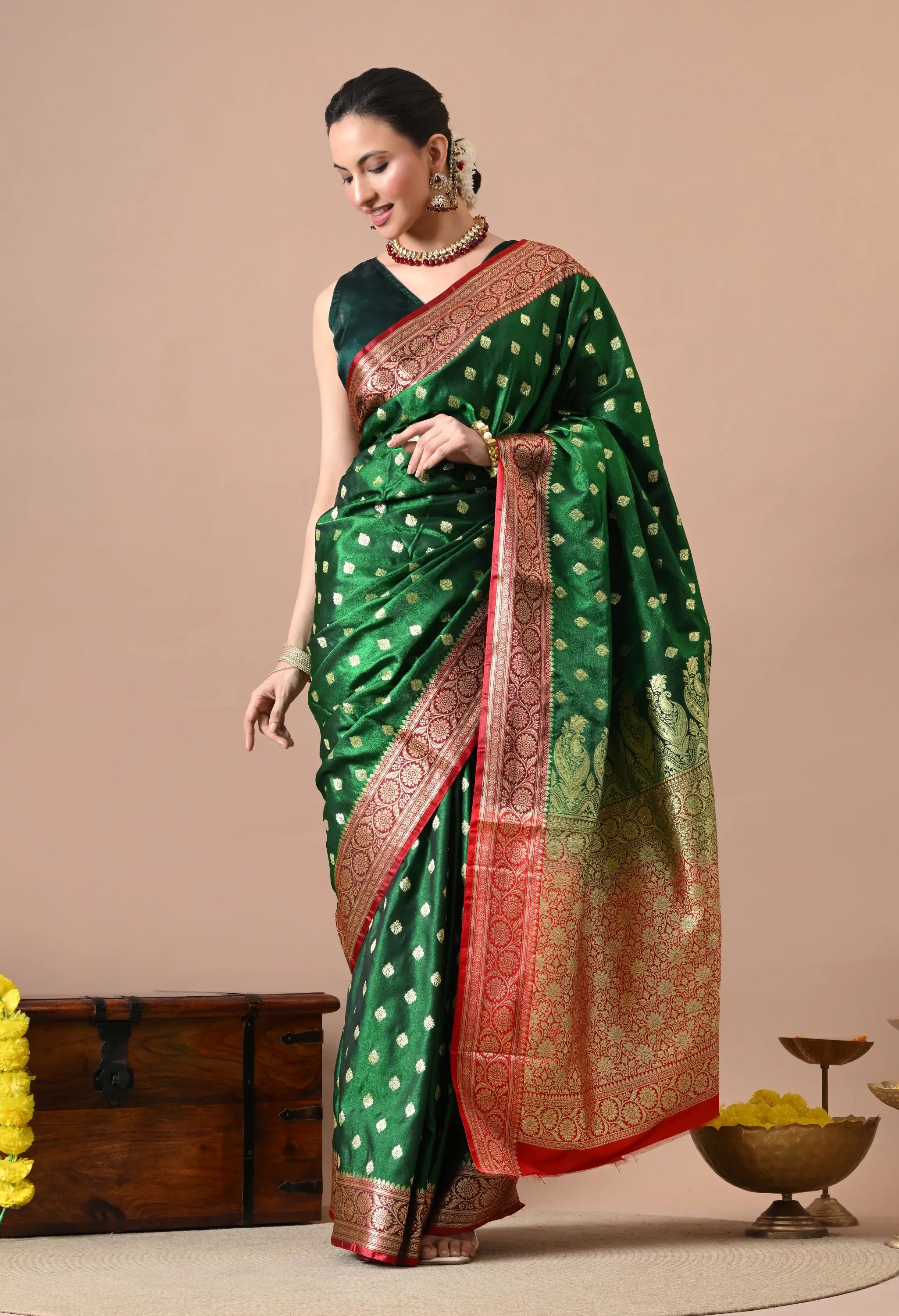 Woman wearing a bottle green and red silk-blend Banarasi saree with gold zari work.

