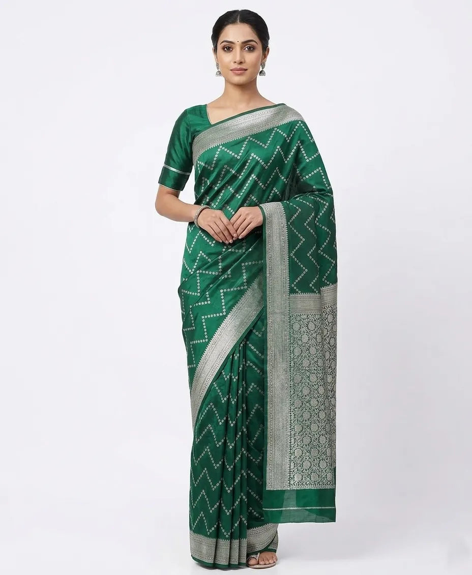 A model wearing a dark green silk blend saree featuring silver zigzag woven patterns and a heavy silver floral zari border, draped elegantly against a white background.