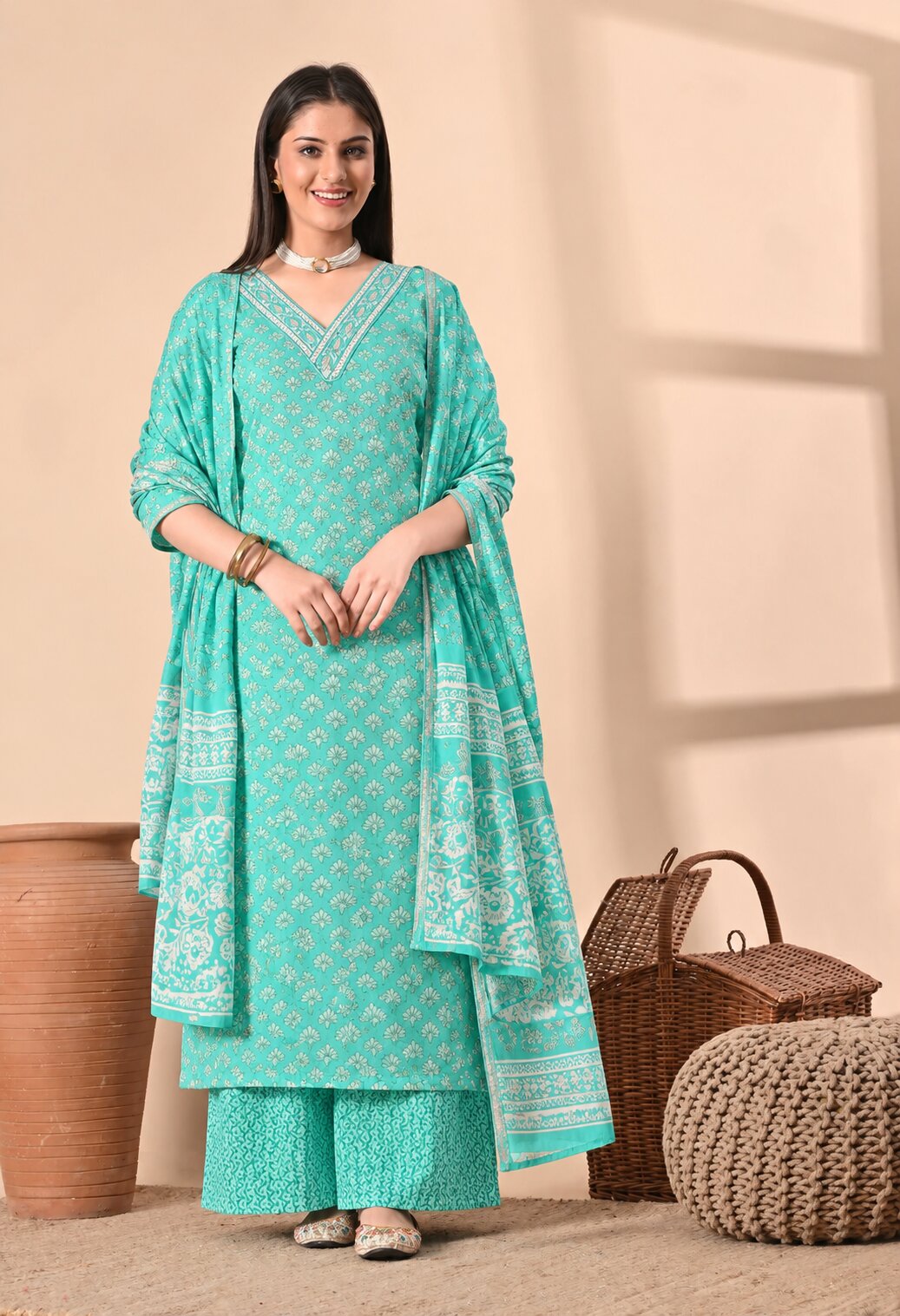 Mint green ethnic kurta suit with white floral prints, V-neckline with decorative detailing, matching wide-leg trousers, and a coordinating dupatta featuring traditional white motifs and patterned borders.