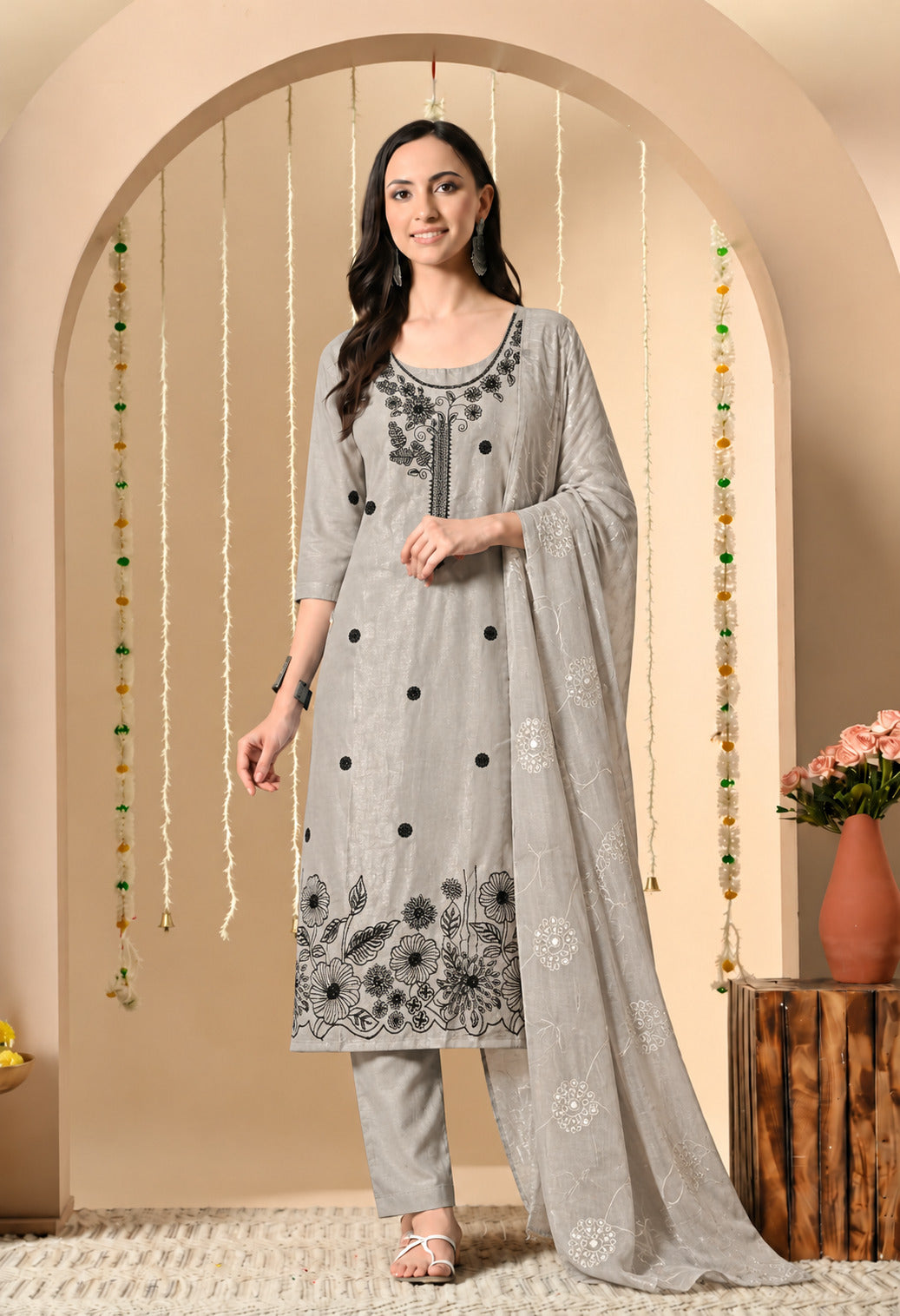 Grey embroidered straight-fit kurta suit set featuring black floral embroidery on the neckline and hem, matching straight pants, and a matching dupatta with delicate white floral motifs.
