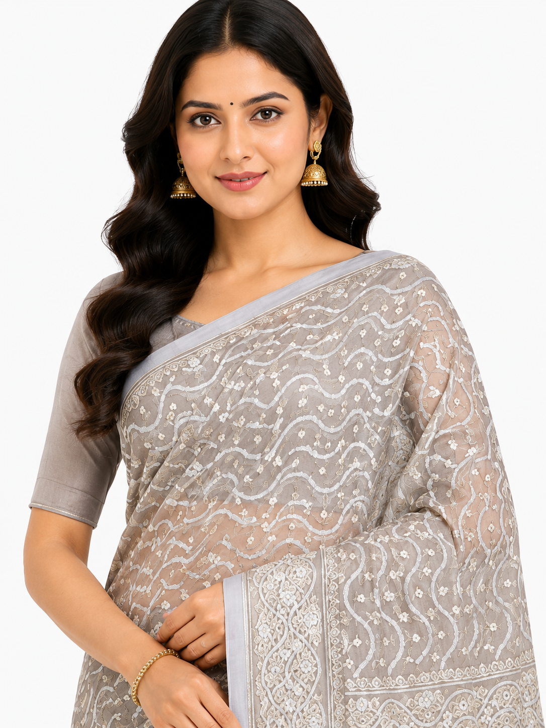 Woman in a grey Banarasi silk blend saree featuring gold Zari wavy patterns, floral buttis, and an ornate geometric pallu.