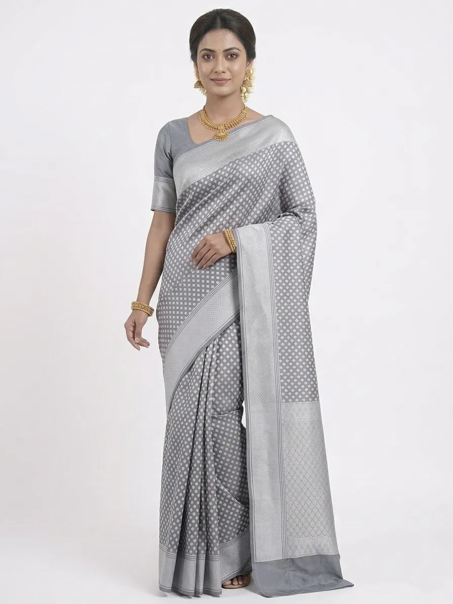 Model wearing a steel grey silk blend Banarasi saree with silver-toned heart-shaped woven motifs, a shimmering pallu, and sleek metallic borders.