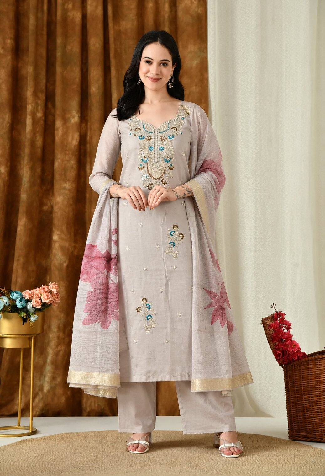 WRite alt text for this suit
Beige ethnic suit set featuring intricate turquoise and gold embroidery on the kurta, matching straight trousers, and a coordinating dupatta with pink floral prints and a golden border. Designed with a round neckline, three-quarter sleeves, and an elegant straight silhouette, perfect for festive occasions, family gatherings, and traditional celebrations.