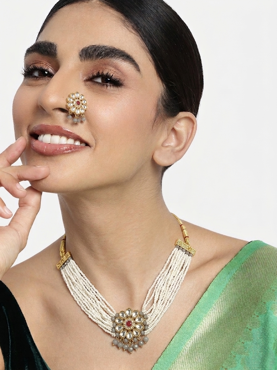 Handcrafted gold-plated Kundan necklace with multi-strand off-white pearls and a floral centerpiece.
