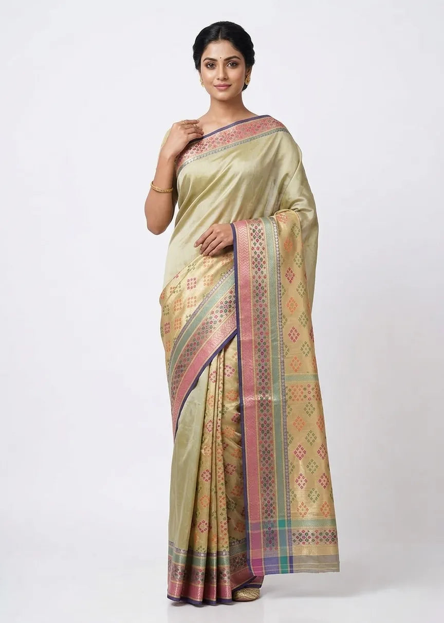 Woman in an olive gold-toned silk blend saree featuring a colorful geometric woven pallu and pink piping.
