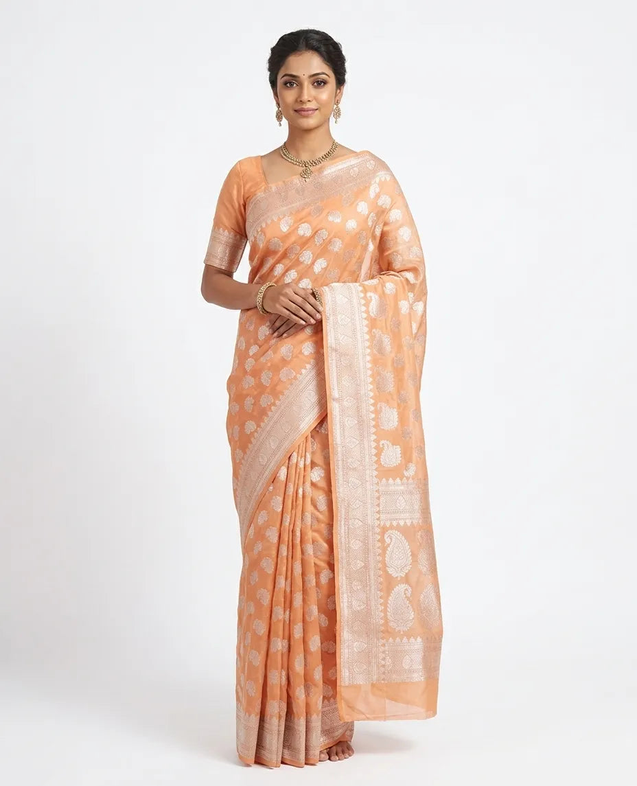 Peach and silver woven design art silk saree with unstitched blouse piece.
