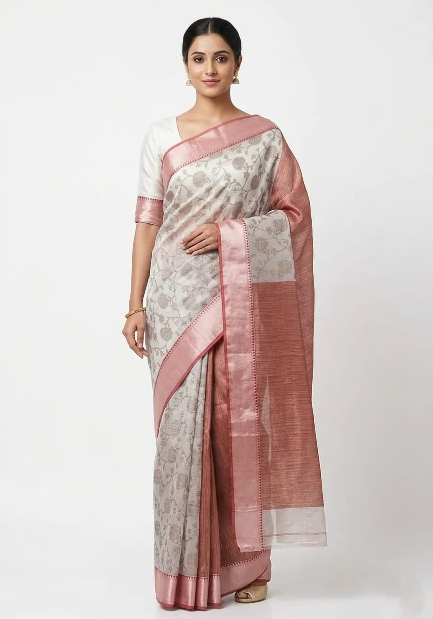 A woman posing in an elegant Off-White Art Silk saree featuring a delicate all-over floral print, paired with a dusty rose-pink textured border and pallu.