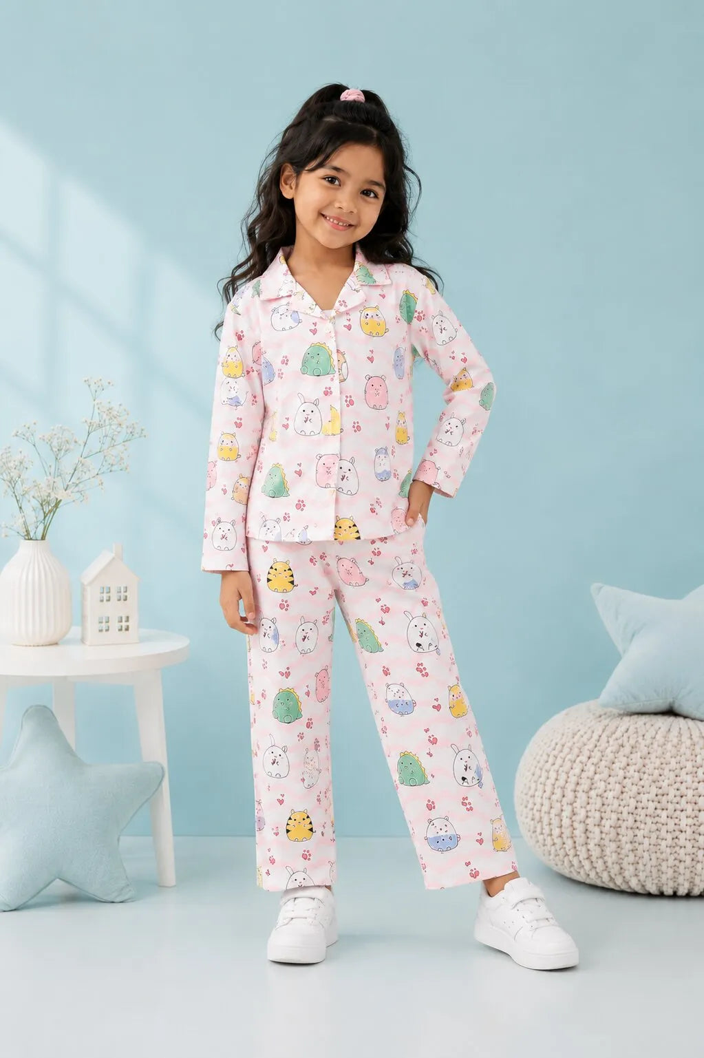 A young Girl standing in a light pink satin night suit featuring a colorful animal and wavy line print.