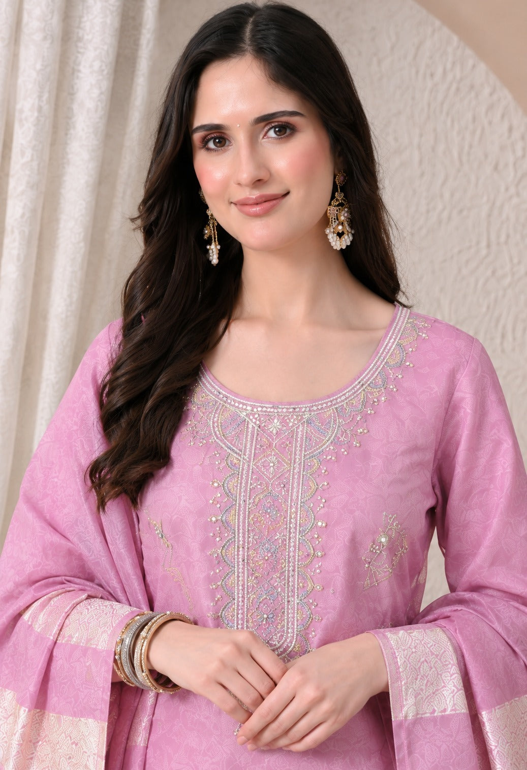 Light pink ethnic kurta suit with intricate silver embroidery around the neckline and front, matching pink trousers, and a coordinating dupatta with silver woven borders.