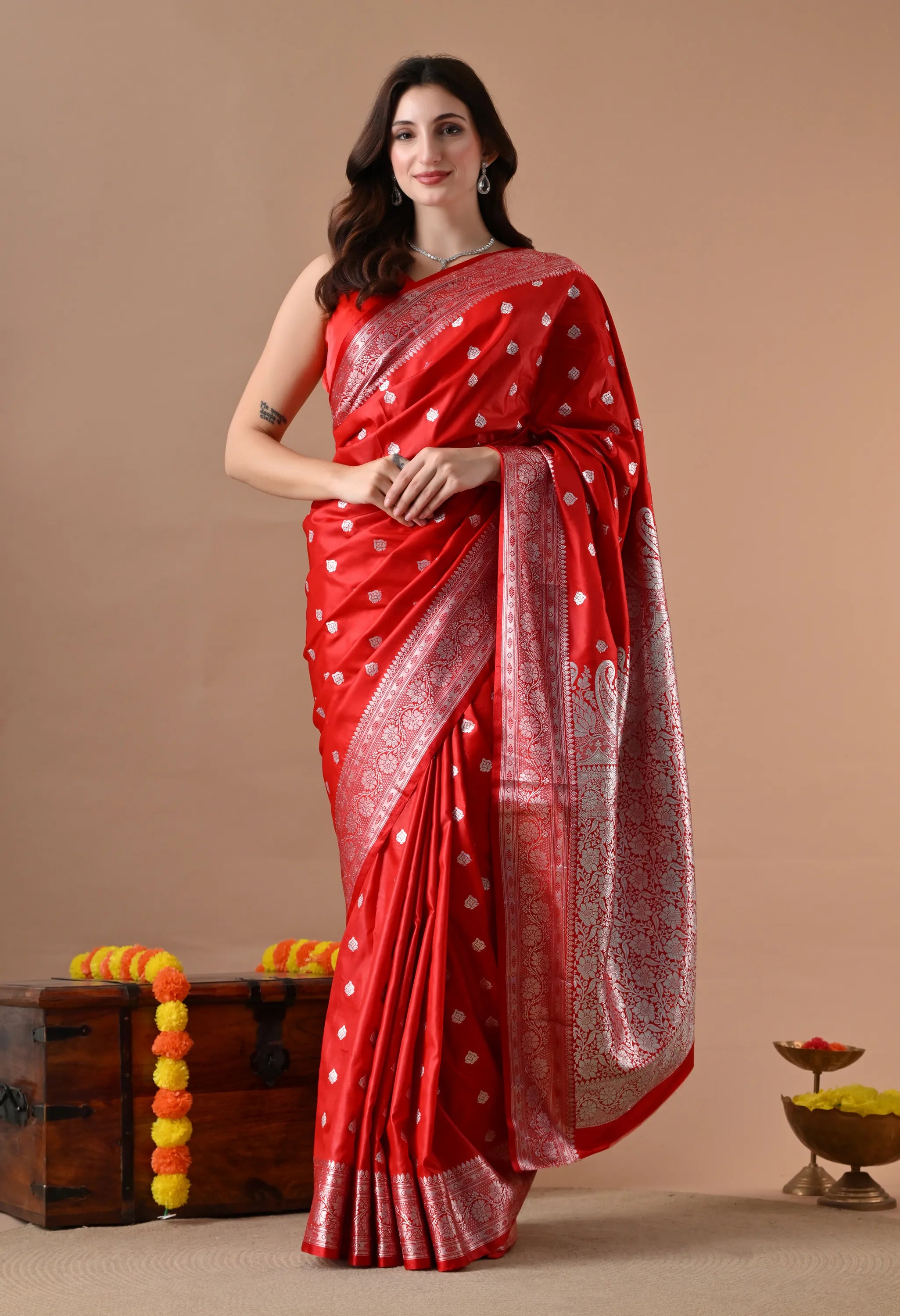 Elegant red Banarasi silk blend saree featuring intricate silver-toned woven floral motifs and a heavy zari border, draped on a model.