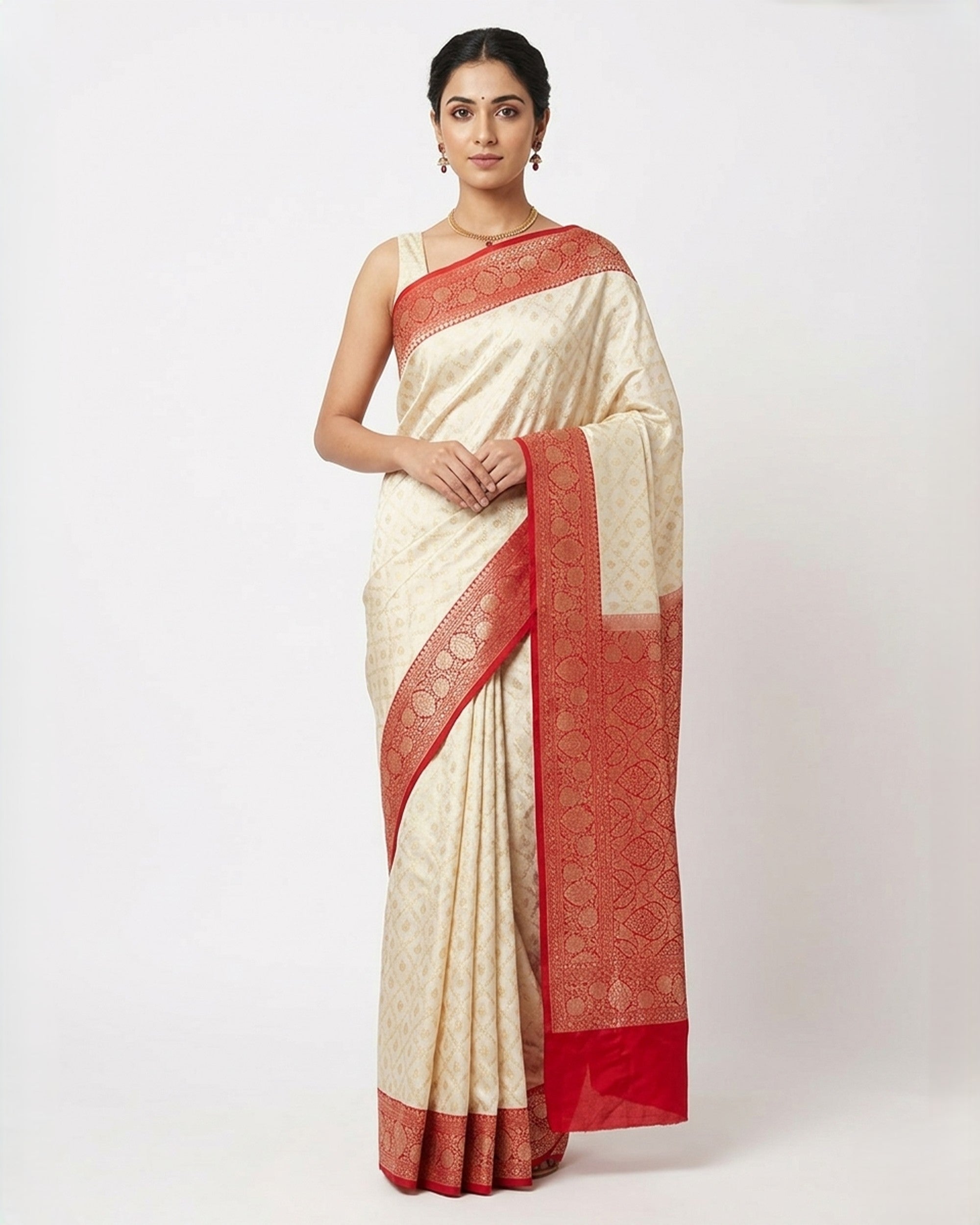 A woman wearing an elegant off-white or cream Banarasi silk saree featuring a contrasting broad red border with gold zari floral patterns, paired with a matching red sleeveless blouse against a plain white background.