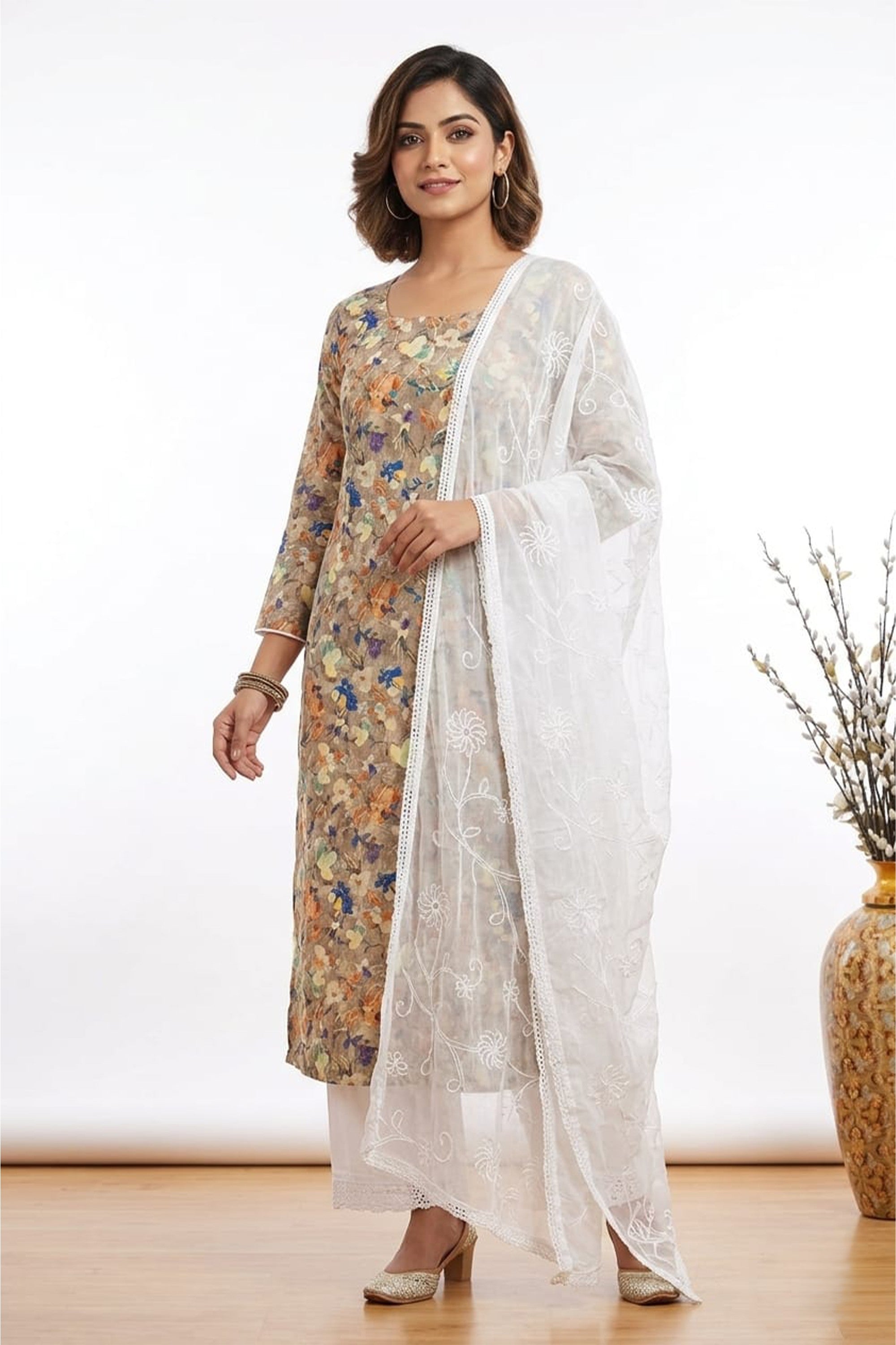 Beige floral printed cotton unstitched suit on a mannequin with a white embroidered net dupatta.
