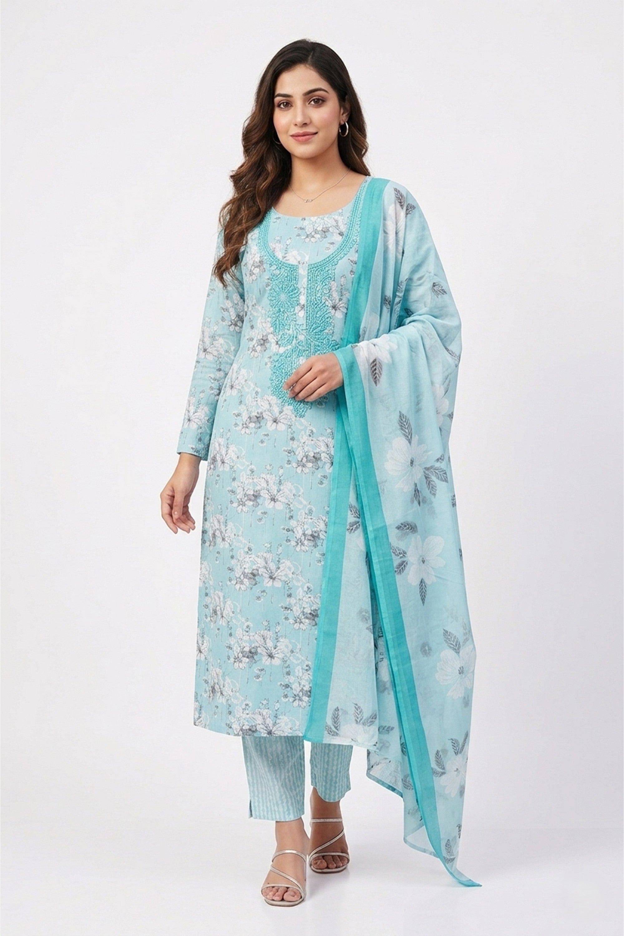A sky blue cotton unstitched suit with white floral prints and a tonal embroidered neckline, shown with a matching dupatta and striped bottom fabric.
