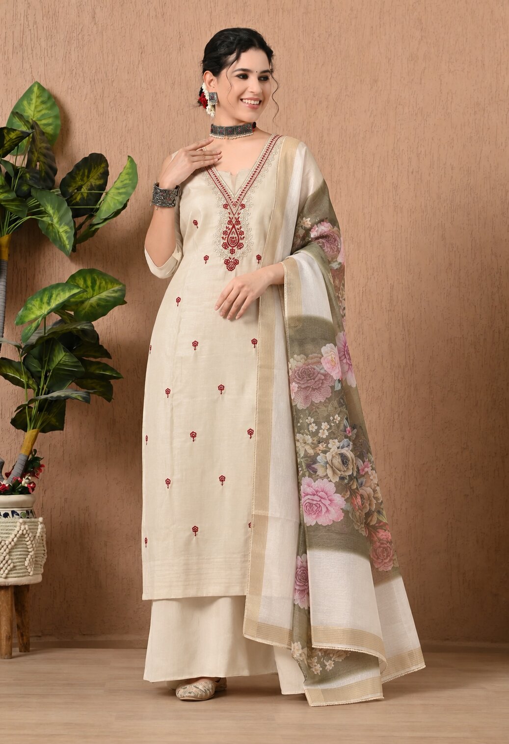 Cream straight kurta suit with red floral embroidery, matching wide-leg trousers, and a beige dupatta featuring pink floral prints and a decorative border.